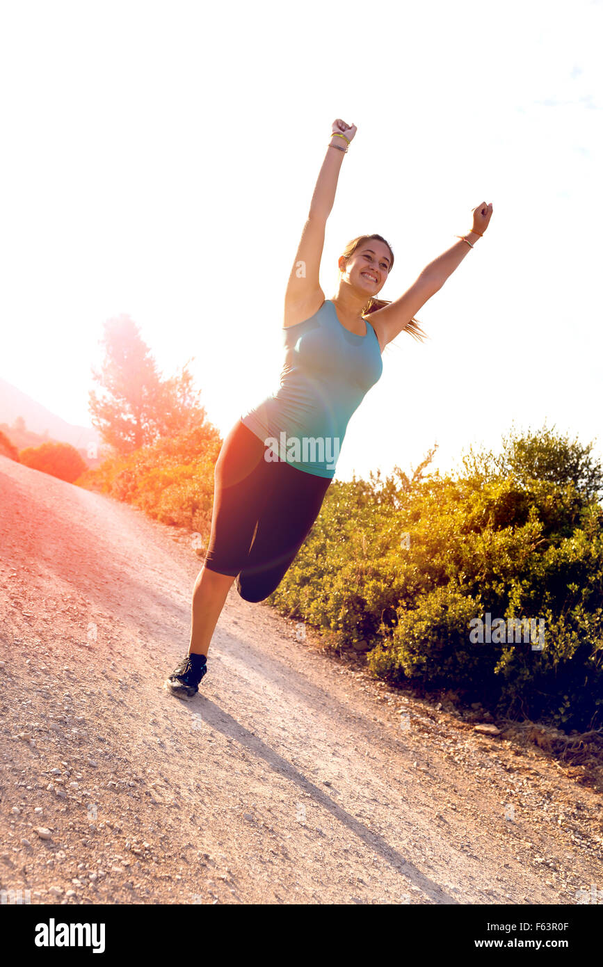 Felice ragazza jogging all'aperto al tramonto ora Foto Stock