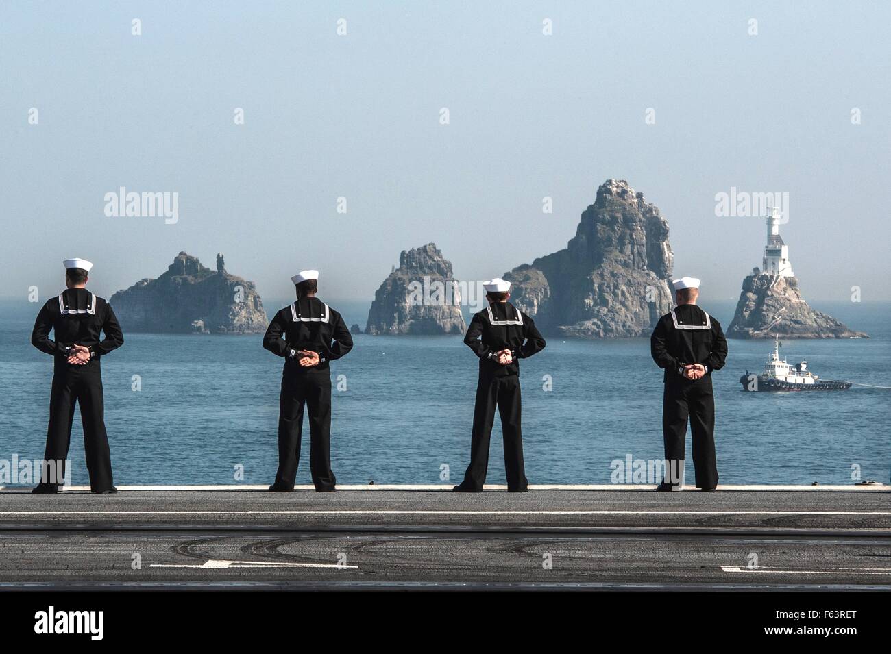 Gli Stati Uniti I marinai della marina stand al resto parata mentre manning le rotaie a bordo della Nimitz-classe-nucleare powered supercarrier USS Ronald Reagan quando si allontana il porto di Busan dopo un avviamento visita porta Novembre 4, 2015 a Busan, in Corea del Sud. Foto Stock