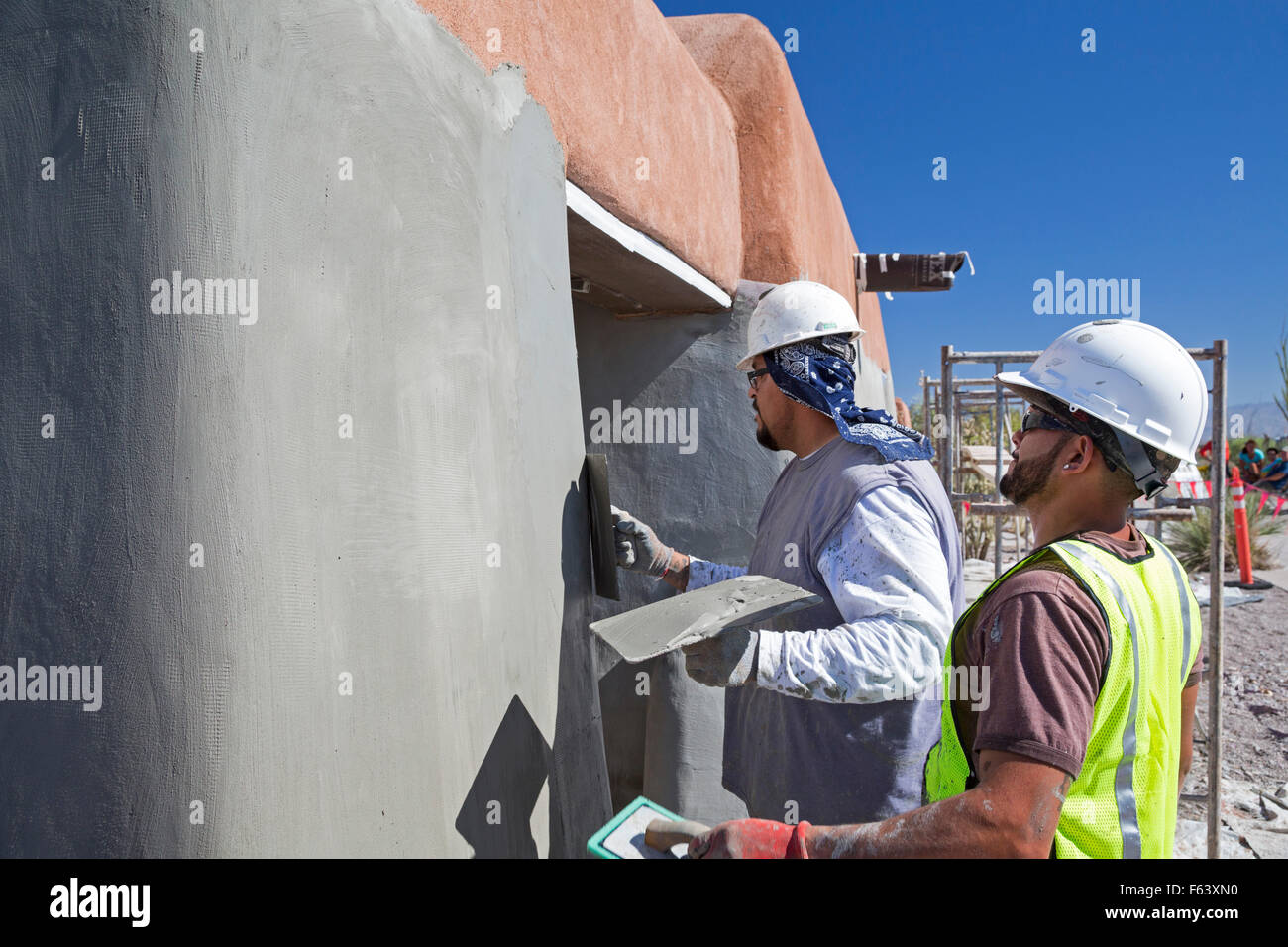 Alamogordo, New Mexico - Lavoratori ri-gesso un edificio di adobe presso il centro visitatori di White Sands National Monument. Foto Stock