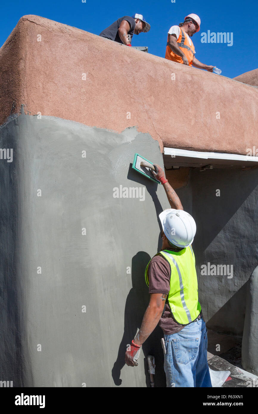 Alamogordo, New Mexico - Lavoratori ri-gesso un edificio di adobe presso il centro visitatori di White Sands National Monument. Foto Stock