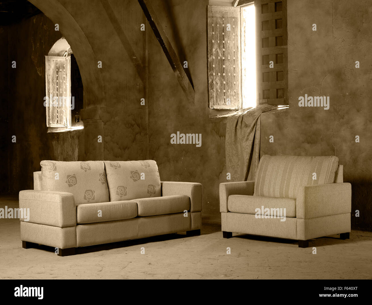 Elementi di uso domestico divano e poltrona in un grande vuoto interno con le finestre aperte Foto Stock