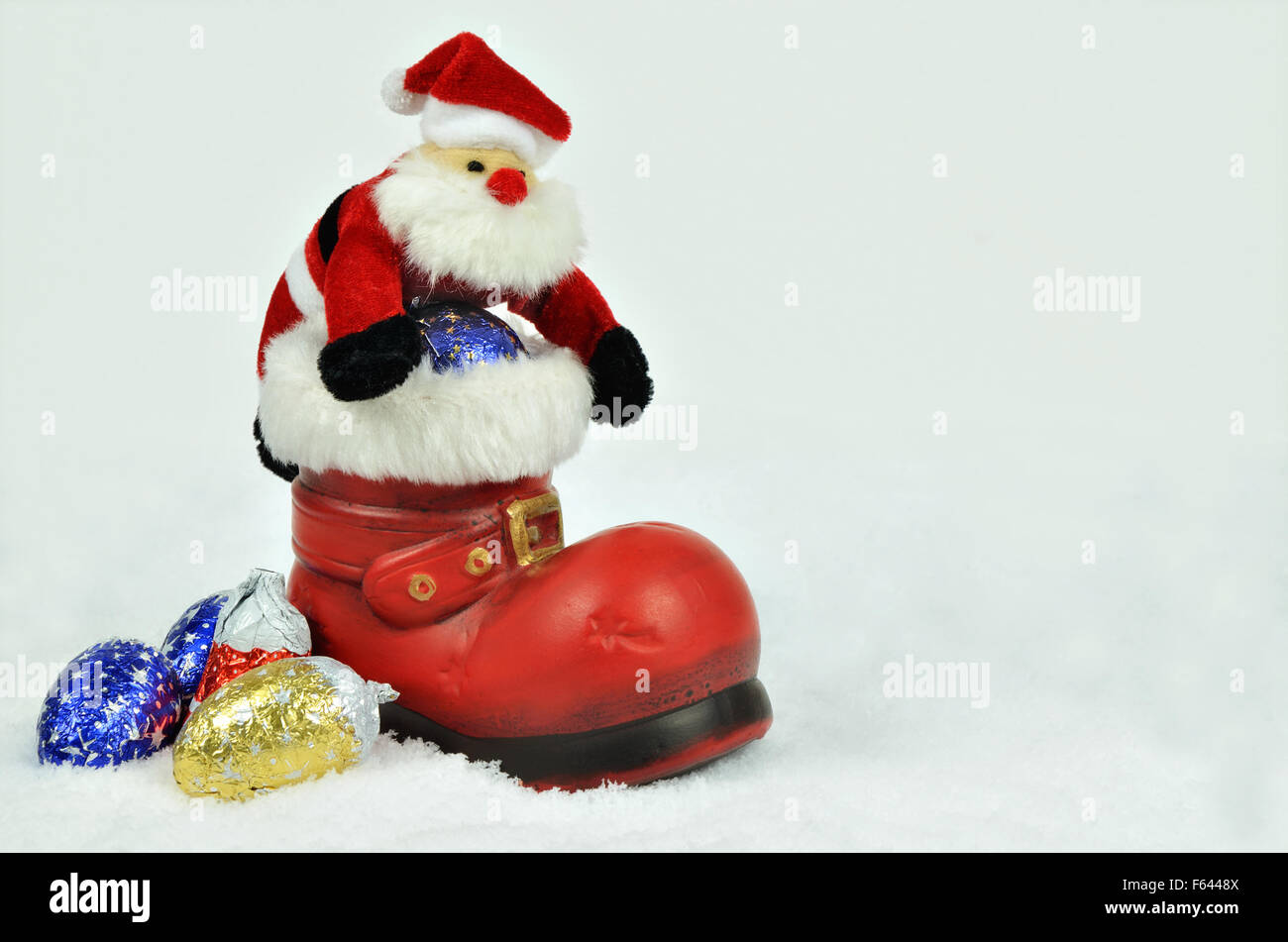 Babbo Natale con rametti di abete all'interno di un parapolvere rosso con pelliccia bianca trimming su bianco, sfondo innevato, close up, orizzontale Foto Stock