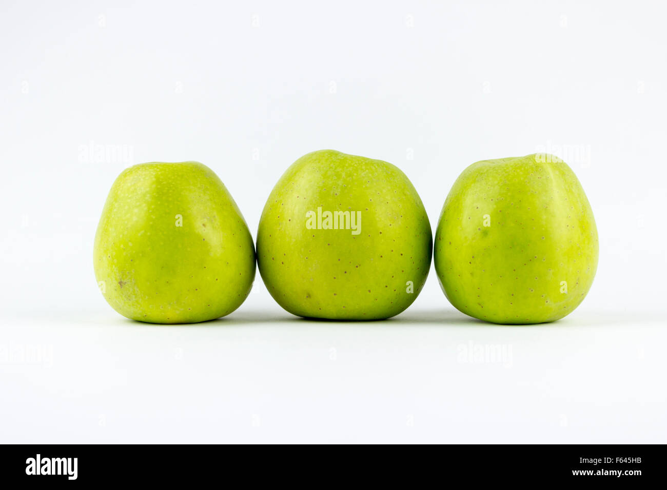 Tre mele verdi, isolato su sfondo bianco Foto Stock