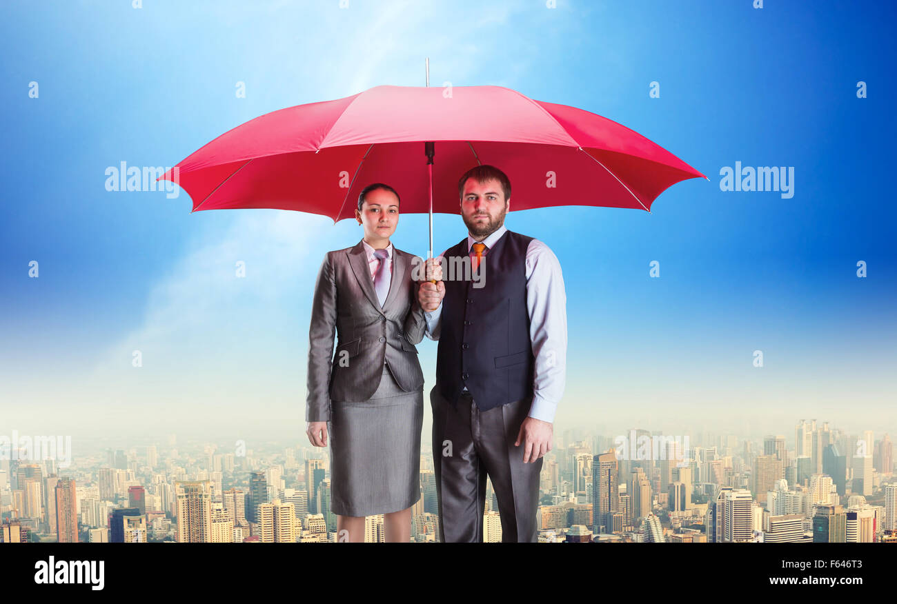 Azienda giovane sotto ombrellone contro il cielo blu Foto Stock