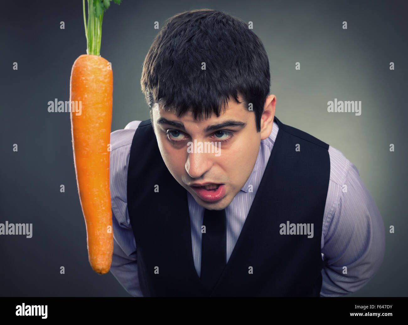 La metafora di esca. Uomo che guarda la carota Foto Stock