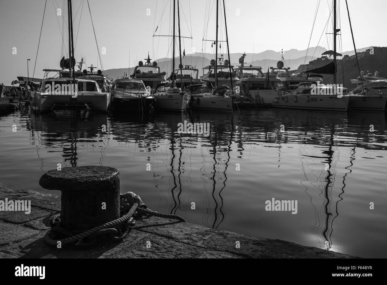 Ancora acqua liscia di vetro tramonto sul bordo delle acque barche oscillanti corda dolce lasco lazy days correnti e leggera brezza, Foto Stock