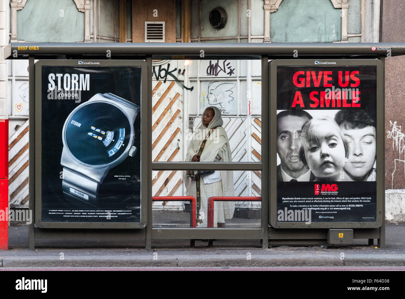 Una donna non identificato attende l'autobus alla fermata su 7 aprile 2007 a Londra, Regno Unito. Foto Stock