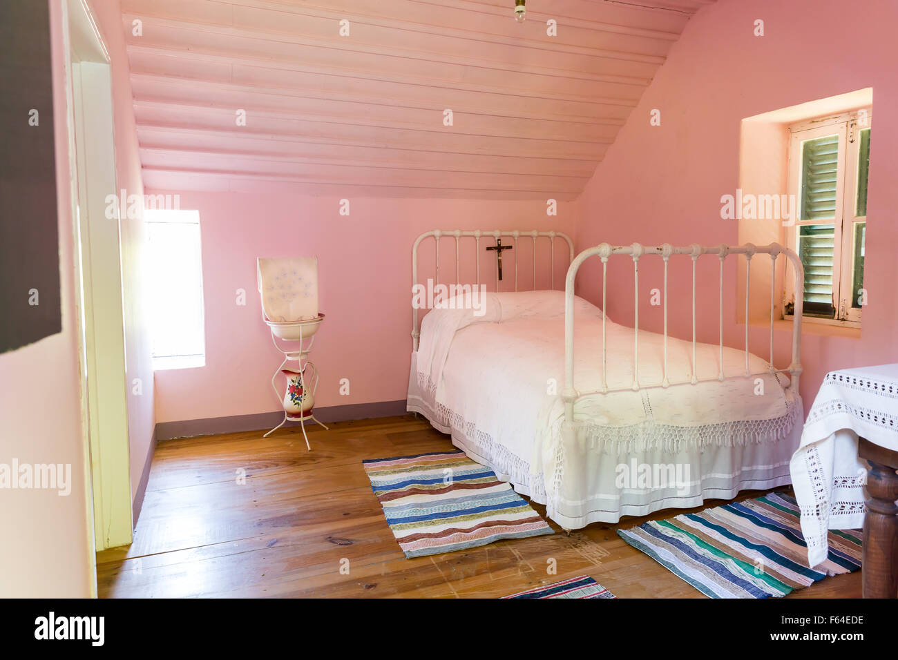 Pulire la camera da letto in hotel in colore rosa con un letto Foto Stock