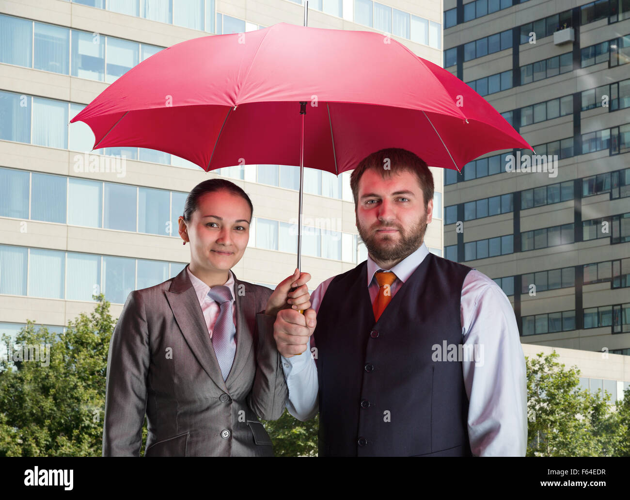 Il team di Business sotto ombrellone contro la città Foto Stock