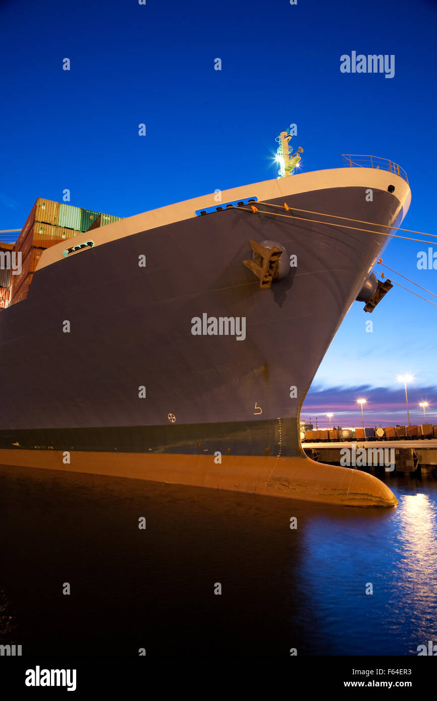 Contenitore di carico della nave a impianto portuale al crepuscolo della notte Foto Stock