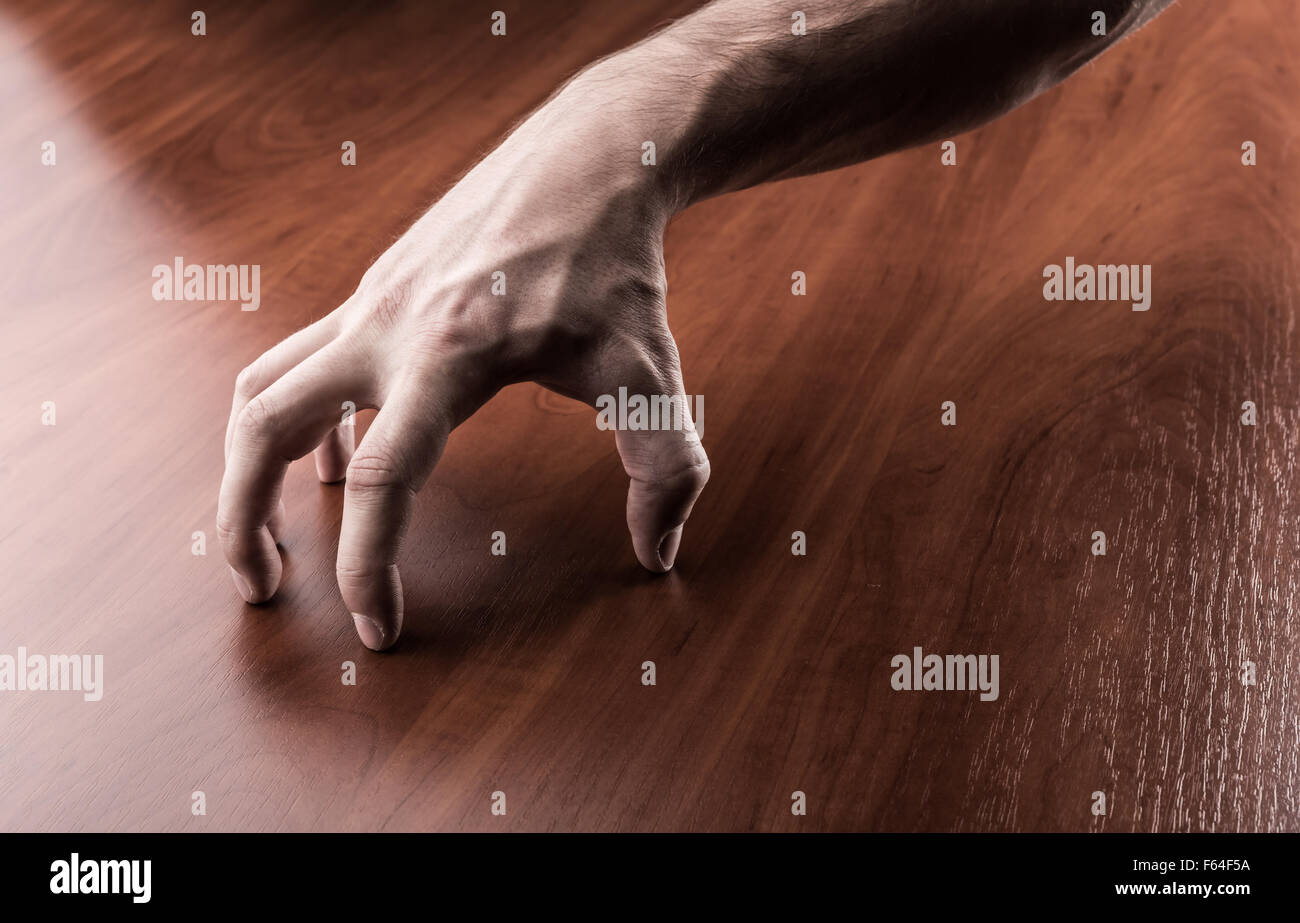 Creepy mano sul tavolo di legno Foto Stock
