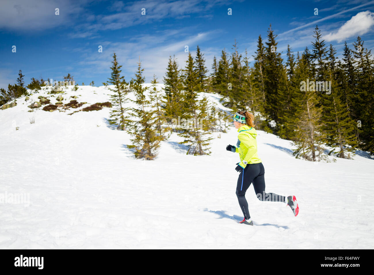 Trail Running donna runner in montagne invernali sulla neve. Ispirazione e motivazione il concetto di fitness con bella vista Foto Stock