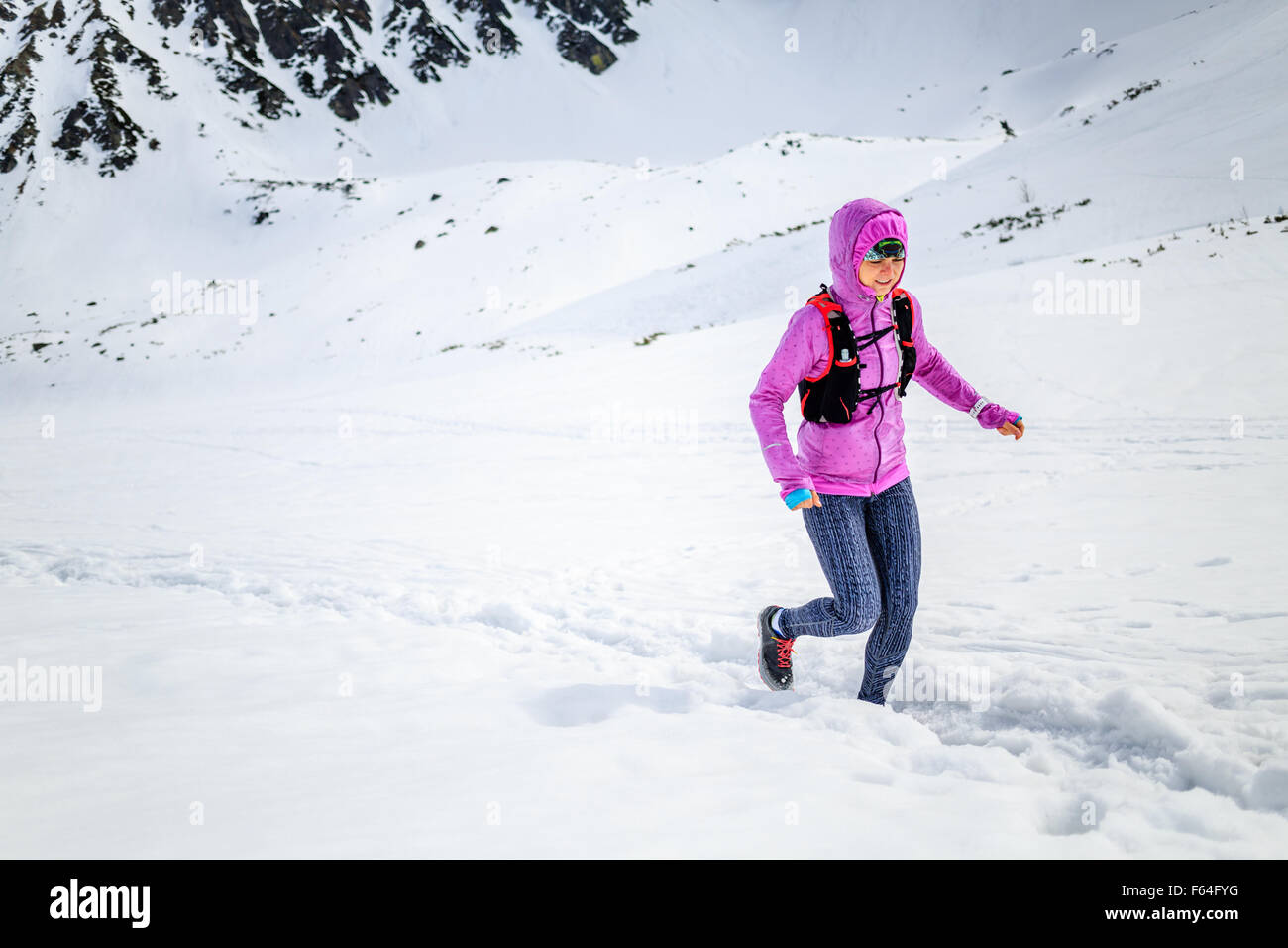 Trail Running donna runner in montagne invernali sulla neve. Ispirazione e motivazione il concetto di fitness con belle viste Foto Stock