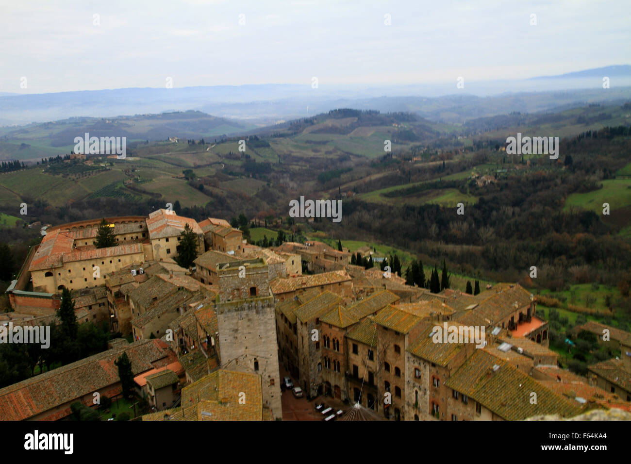 La città delle belle torri di San Gimignano con vista sui tetti della città e bellissime colline toscane di Siena, Italia. Vista aerea Foto Stock