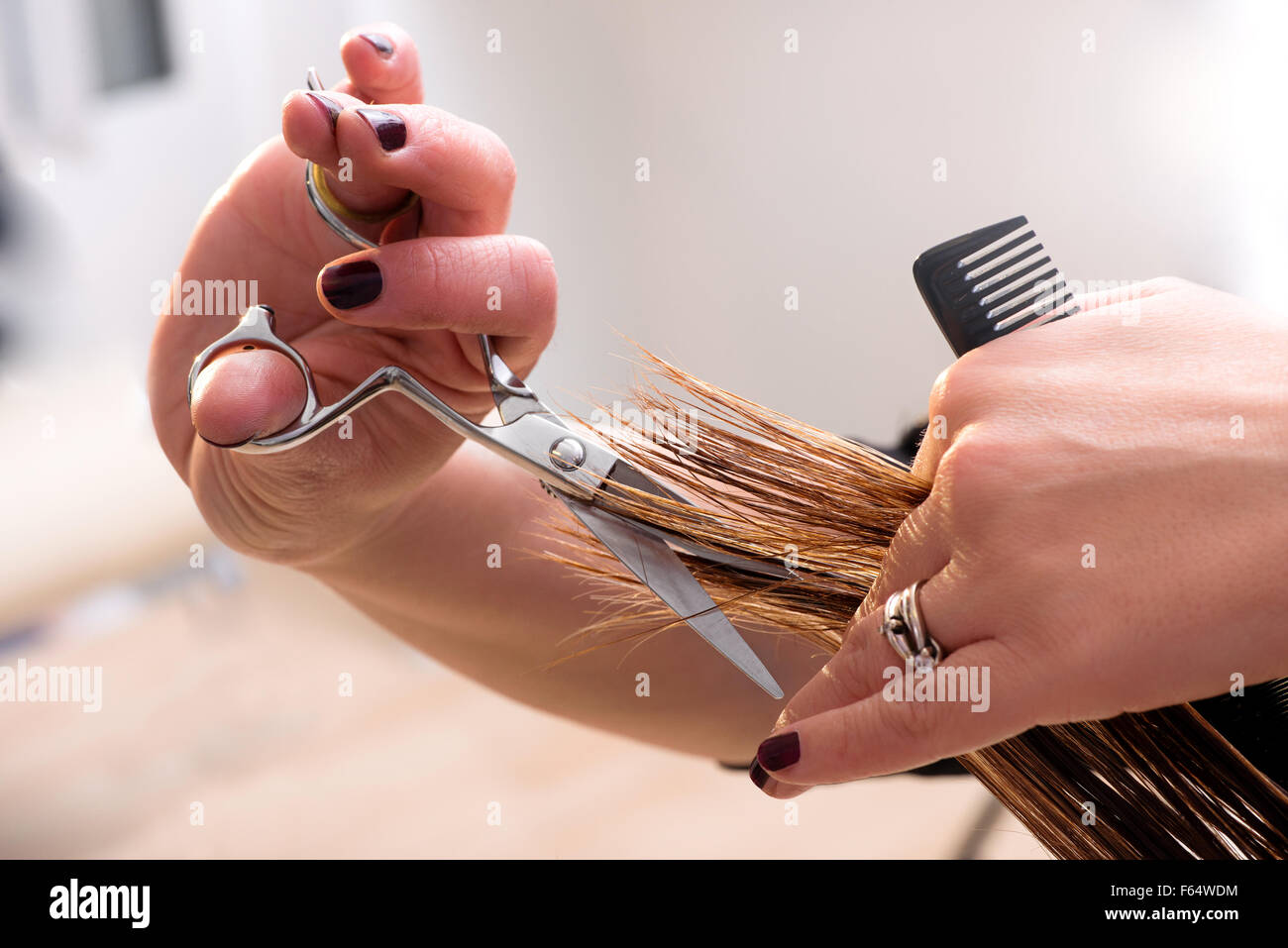 Parrucchiere rifilatura delle estremità sui capelli Foto Stock