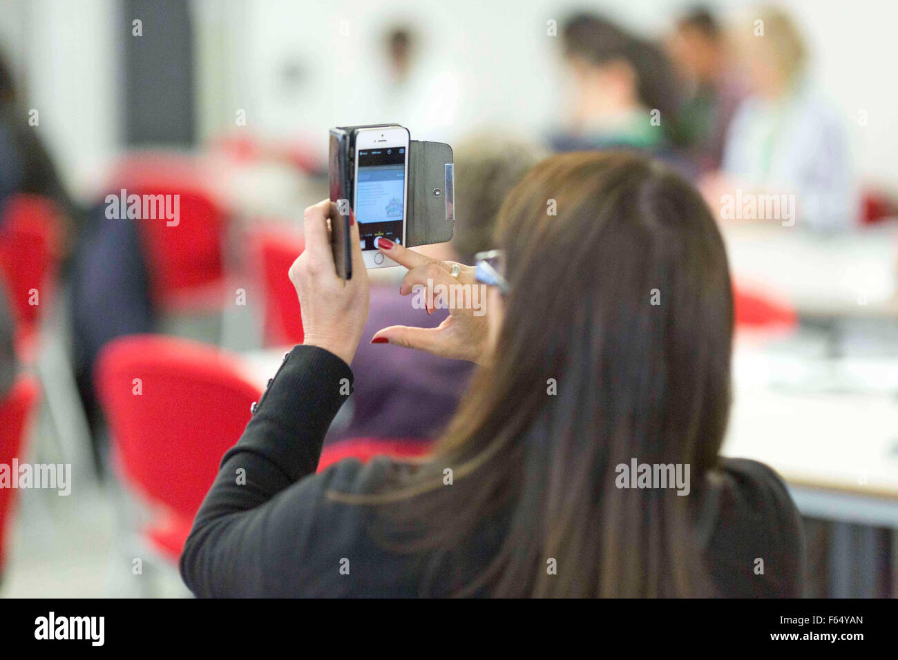 Una donna usa uno smartphone per scattare una foto Foto Stock