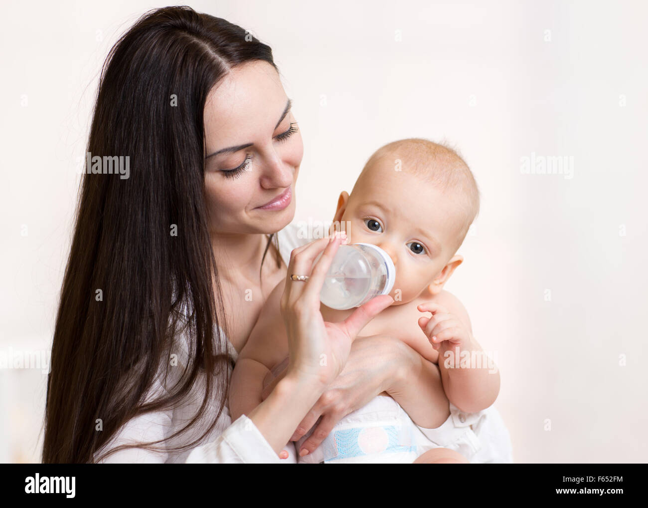 Madre dà a bere acqua baby Foto Stock