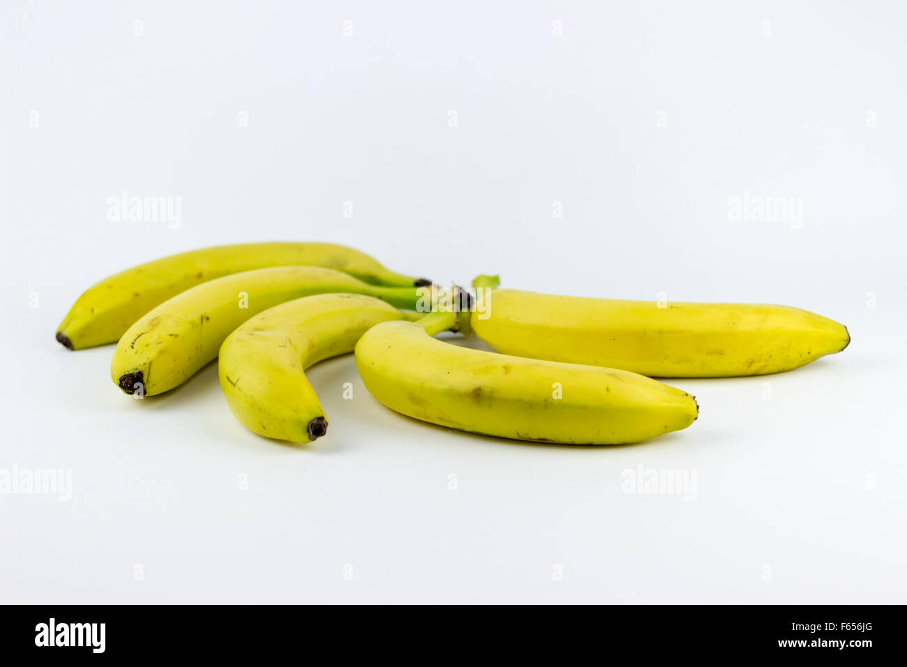 5 banane, isolato su uno sfondo bianco Foto Stock