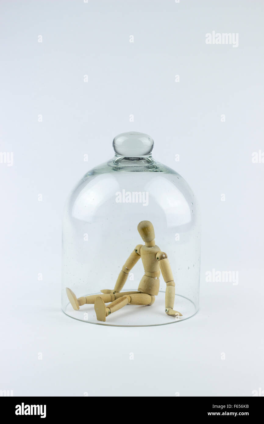Legno Puppet intrappolato in una campana di vetro gabbia, su sfondo bianco Foto Stock