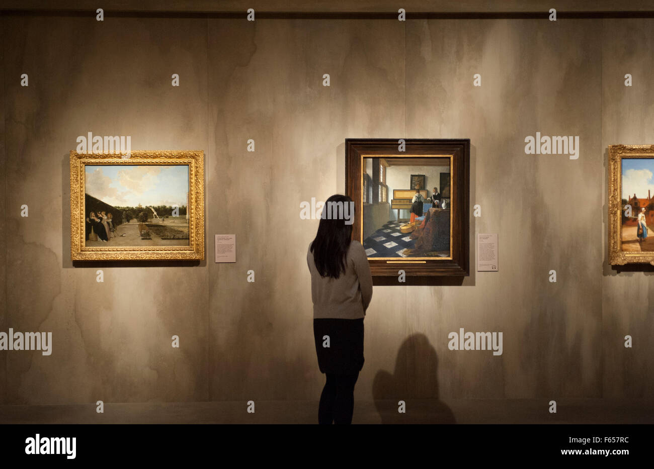 La Queen's Gallery e Buckingham Palace, London, Regno Unito. 12 Novembre, 2015. Il primo dipinto di Rembrandt van Rijn per raggiungere l'Inghilterra e uno di meno di 40 noti dipinti di Johannes Vermeer sono tra i punti salienti dei maestri del quotidiano: artisti Olandesi in età di Vermeer, una nuova mostra dalla Collezione Reale apertura venerdì 13 novembre 2015. Un membro del personale galleria esamina la signora alla virginali con un gentiluomo, o 'La lezione di musica", 1662-5, da Johannes Vermeer, uno di meno di quaranta dipinti da attribuire all'artista oggi. Credito: artsimages/Alamy Live News Foto Stock