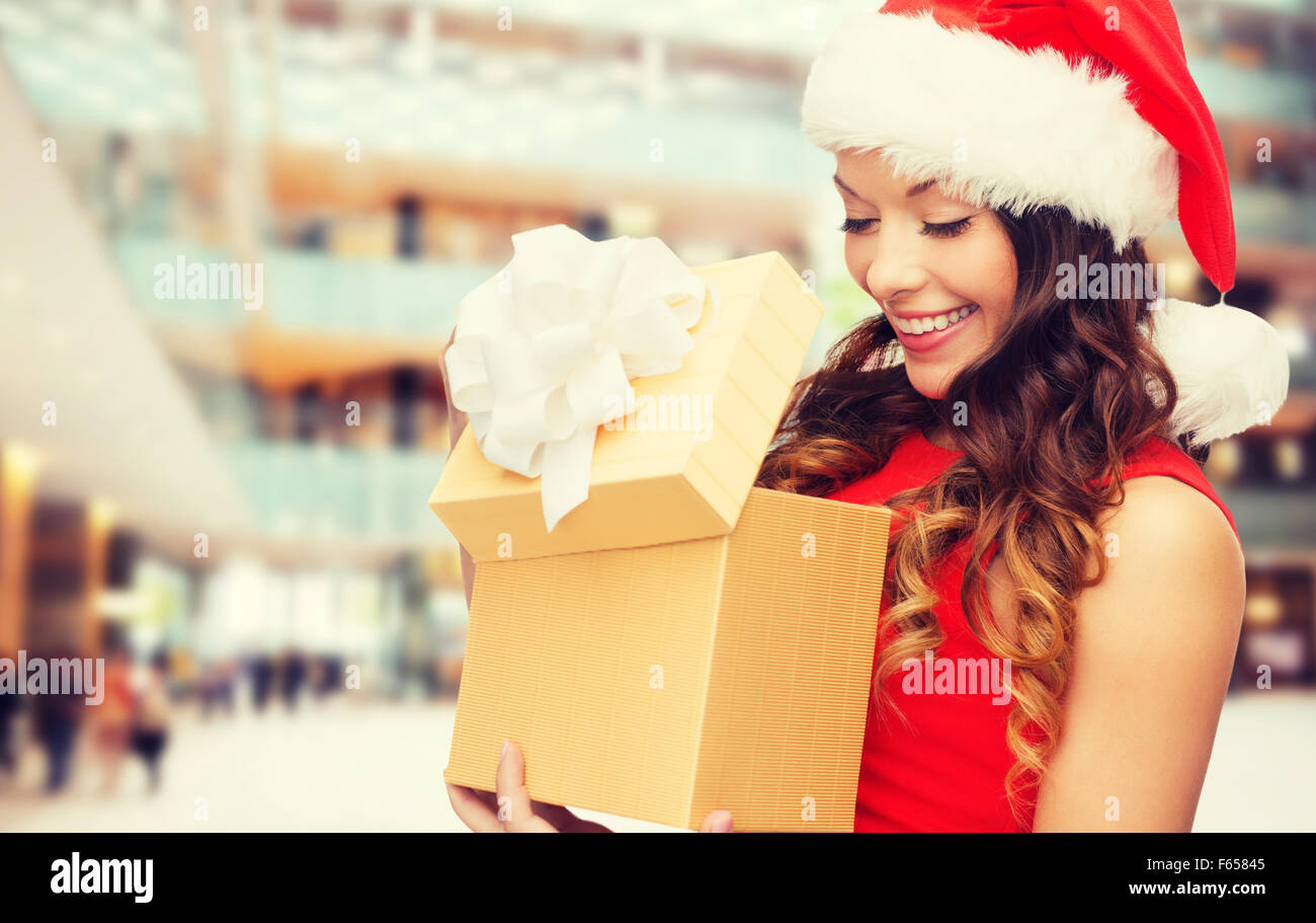 Donna sorridente in abito rosso con confezione regalo Foto Stock