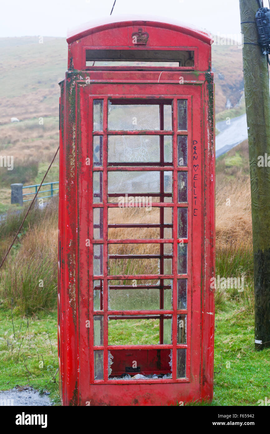 Rovinato abbandonato telefono rosso casella in una posizione rurale isolata nel Mid Wales Regno Unito miglia dalla civiltà nel mese di novembre Foto Stock