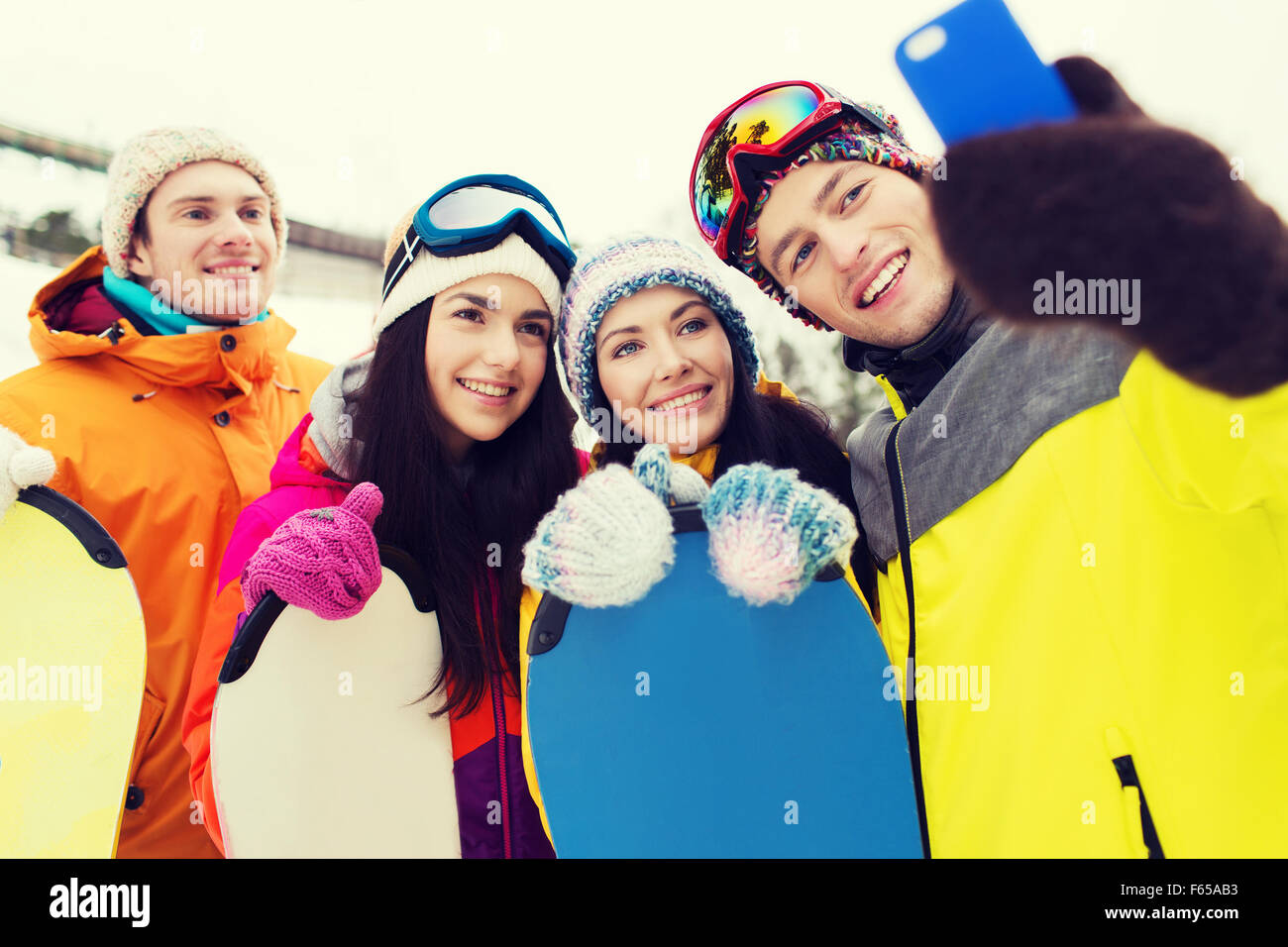 Happy amici con racchette da neve e lo smartphone Foto Stock