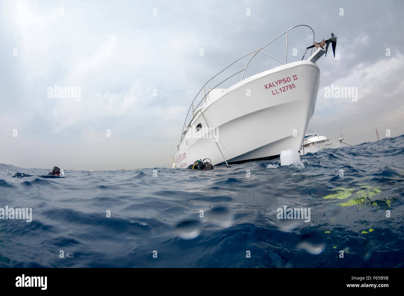 La barca è ancorata in prossimità del sito di immersione e i subacquei sono entrati a far parte dell'acqua fotografati della costa di Larnaca, Cipro Foto Stock