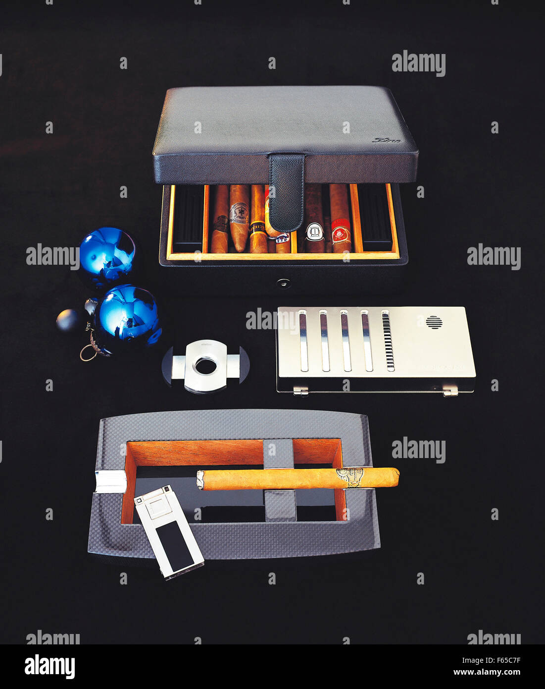 Travel humidor sigaro portacenere, accendini e coltello da caccia su sfondo nero Foto Stock
