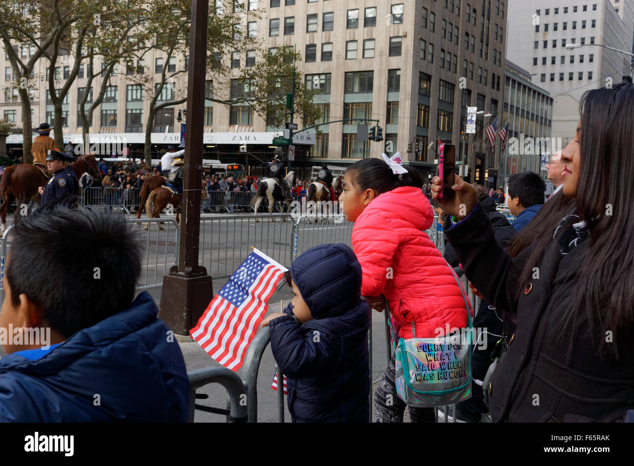 Una famiglia guardando i veterani parata del giorno sulla Fifth Avenue a New York City. Foto Stock
