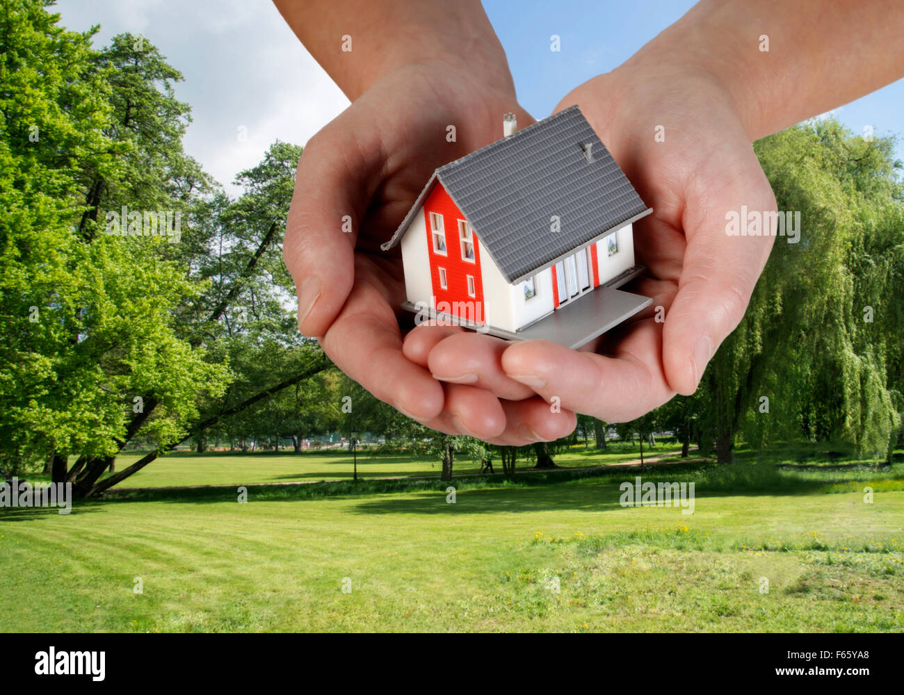 Le mani con la casa di fronte ad un edificio trama Composito Digitale (CC) Foto Stock