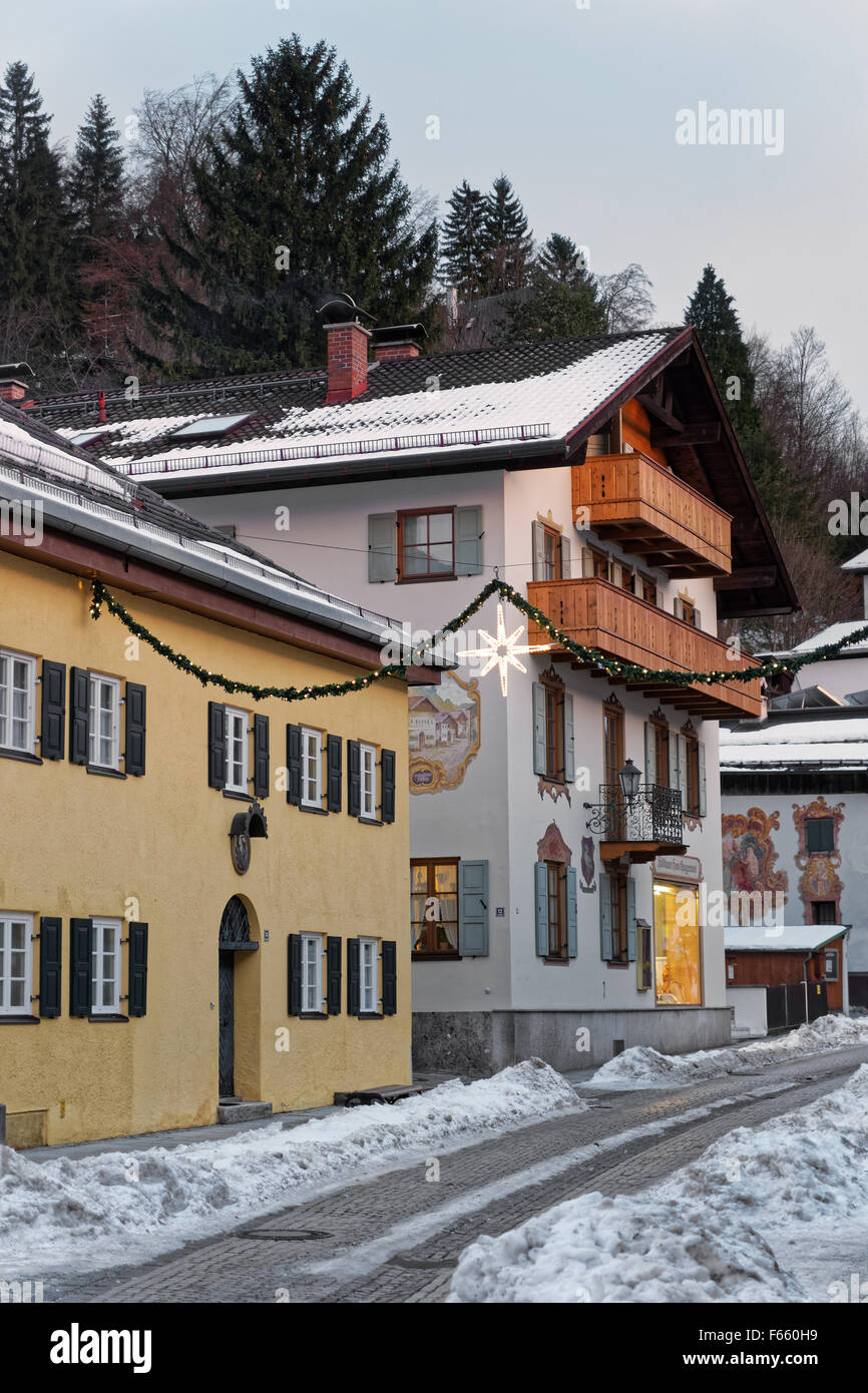 Strada innevata di Garmisch-Partenkirchen unico con murales sulle pareti esterne degli edifici. Questo tipo di pittura della facciata è un completamente indipendente, Tedesco forma d'arte Foto Stock