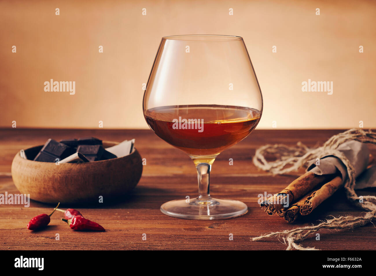 Bicchiere da snifter con cognac (golpaccio di brandy, ciotola di brandy,  bicchiere di cognac o palloncino) adagiato su uno sfondo nero con riflesso.  Vetreria per la fronte invecchiata Foto stock - Alamy