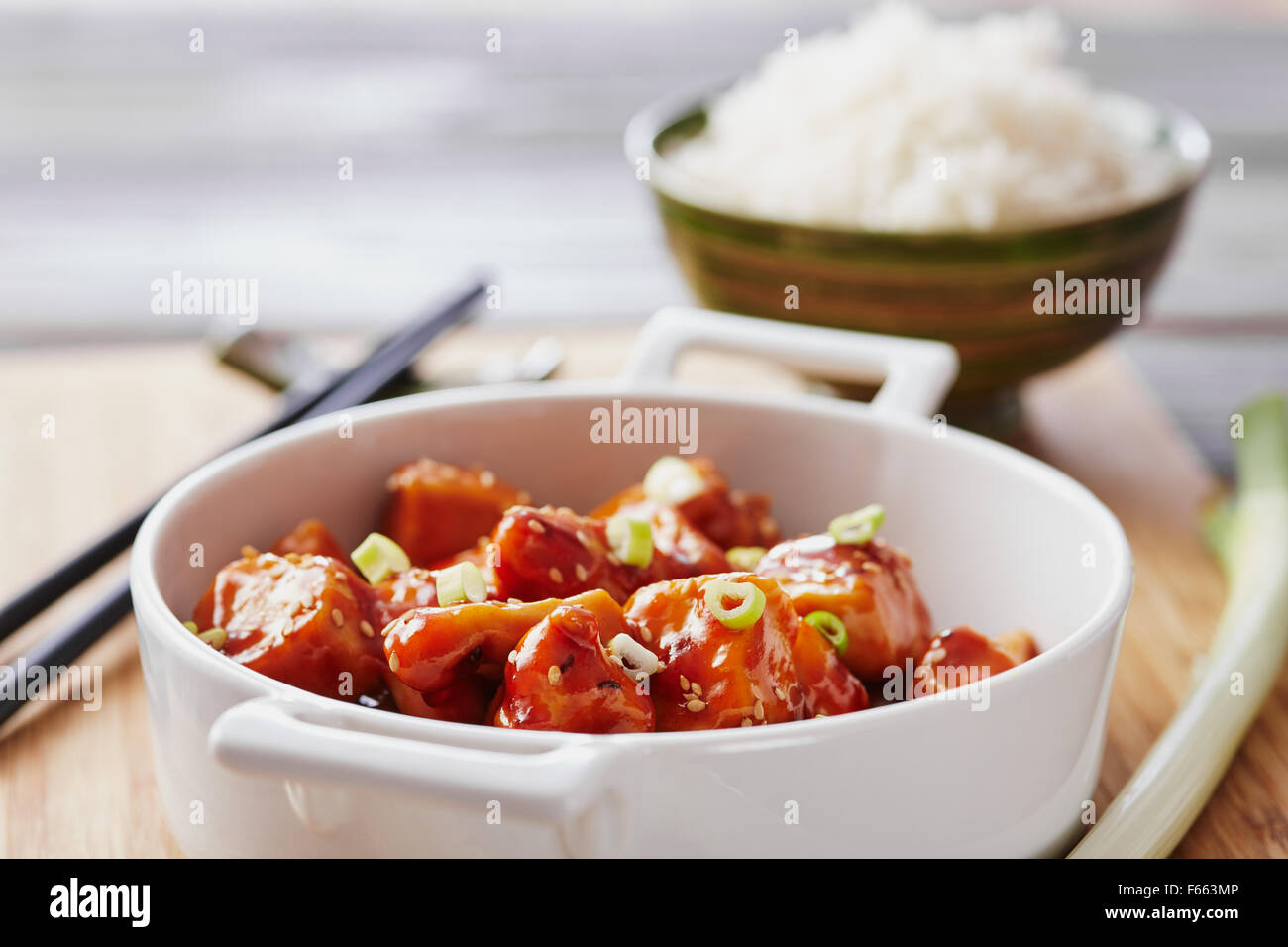 Il pollo al forno di sesamo su un bambù tagliere con riso basmati Foto Stock