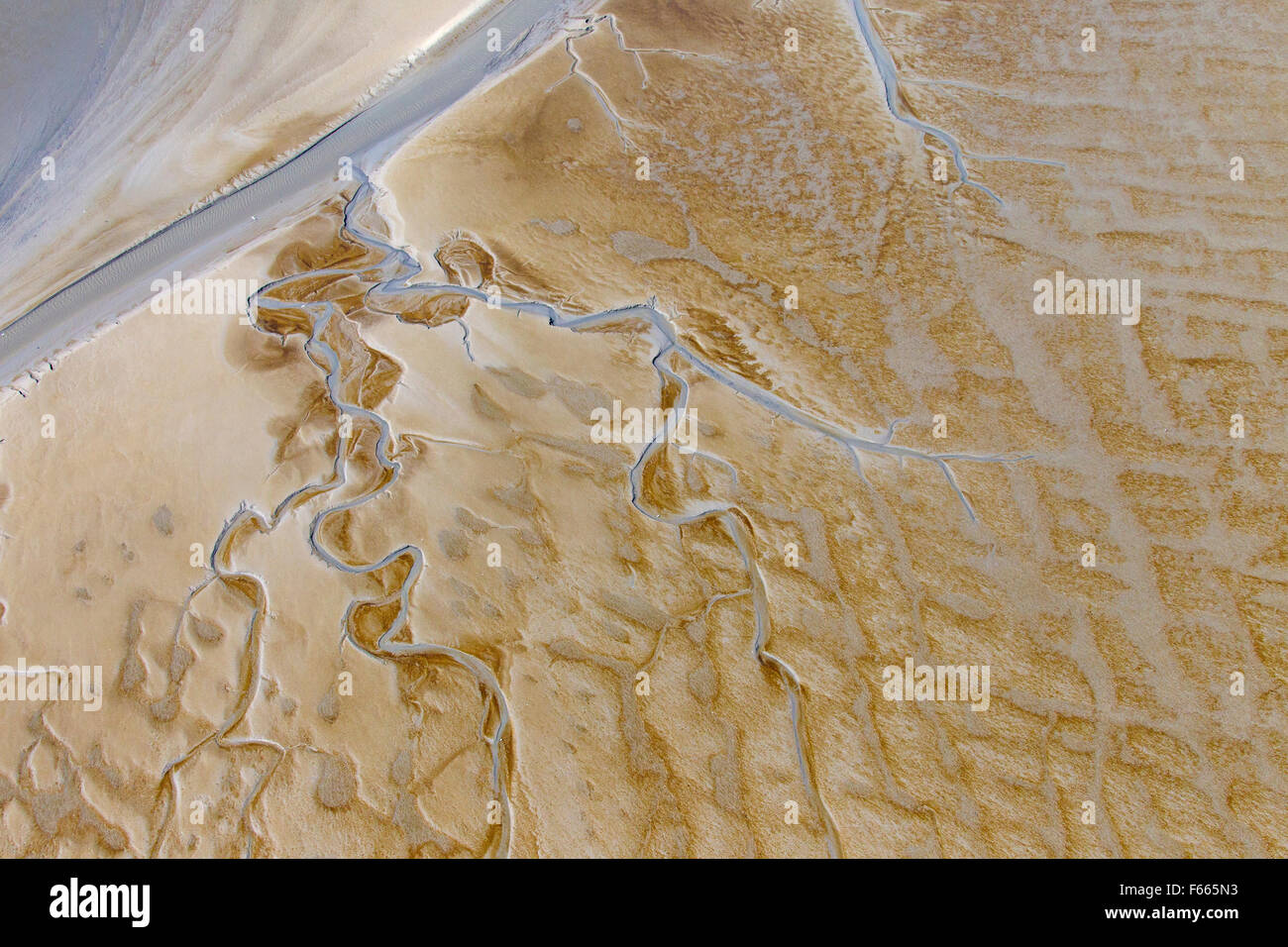 Vista aerea del flusso di avvolgimento in esecuzione attraverso mudflat marea Foto Stock