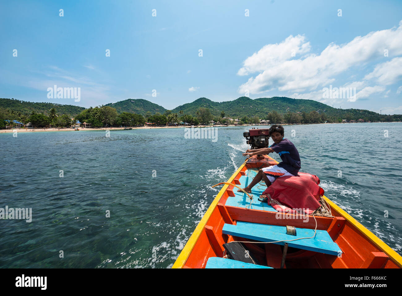 Uomo locale lo sterzo longtail boat dalla parte posteriore, il mare turchese, isola di Koh Tao, Golfo di Thailandia, Tailandia Foto Stock