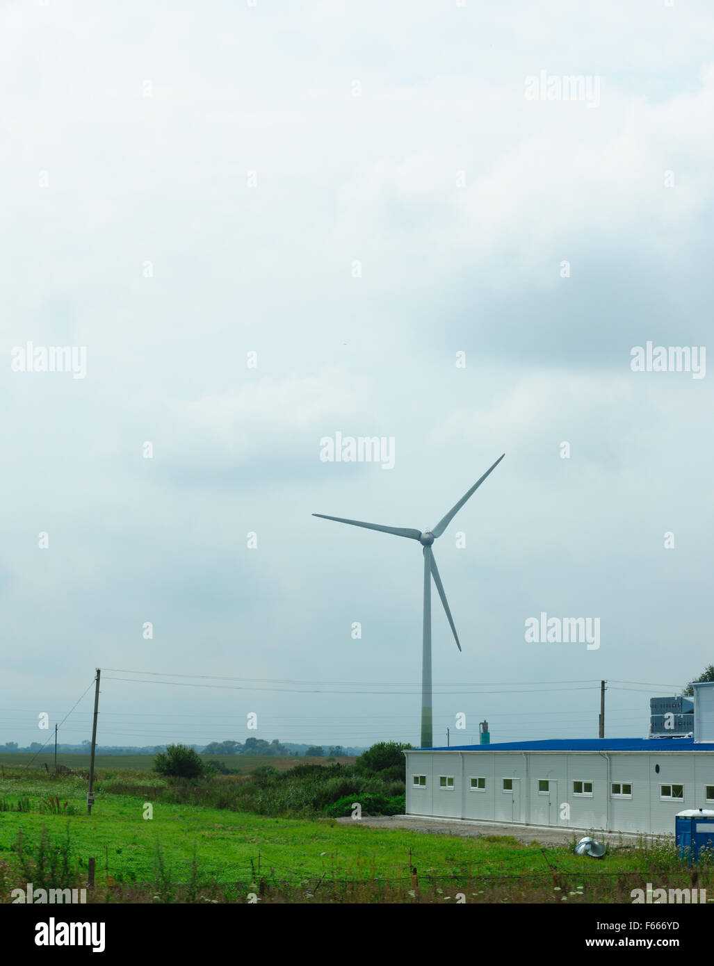 Il vento generatore azionato a mezzo di un campo serve per lo sviluppo dell'a buon mercato ed ecologia energia elettrica Foto Stock