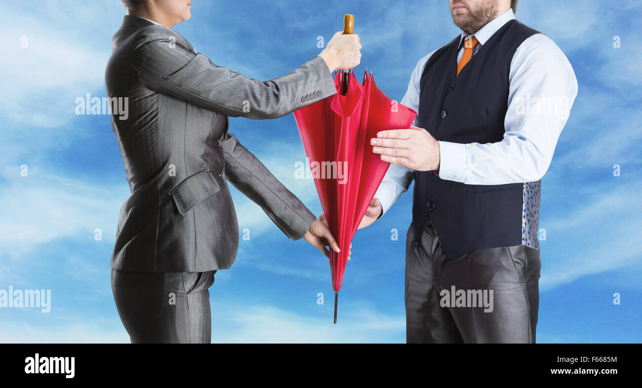 Imprenditrice dà ombrello come simbolo per imprenditore contro il cielo Foto Stock