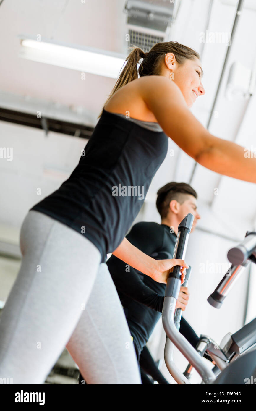 Montare bella giovane donna che lavora fuori su uno stepper insieme con i suoi amici Foto Stock