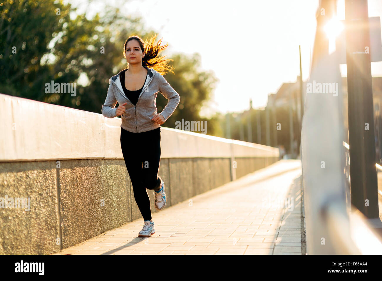 Bellissima femmina jogging in città e mantenendo il suo corpo in forma Foto Stock