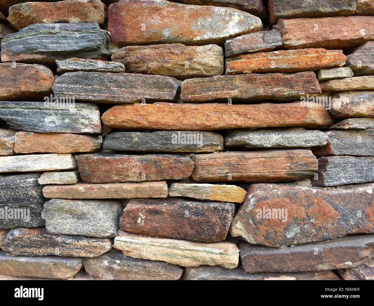 Muro di pietra motivo dal vecchio log cabin camino Foto Stock