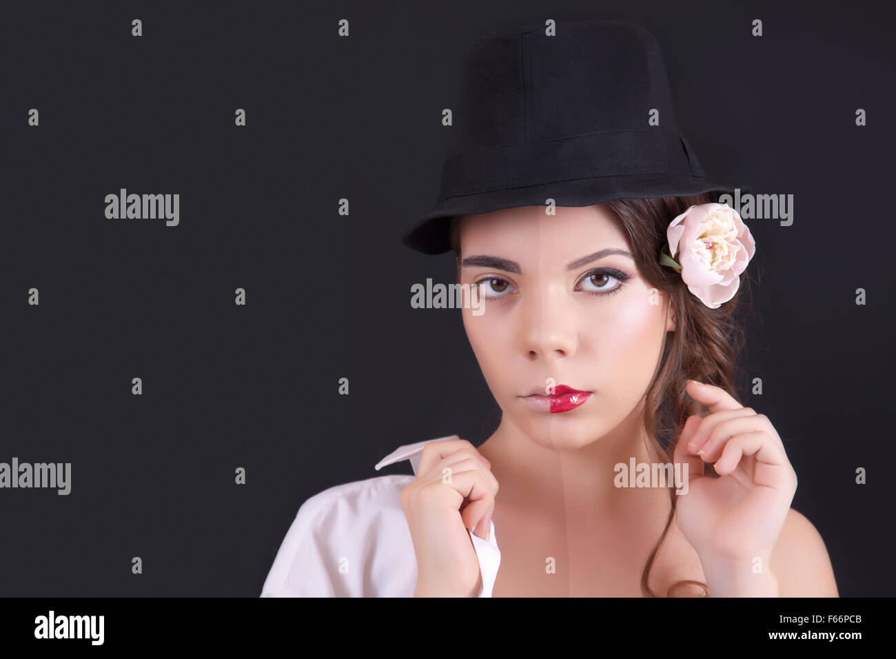 Ritratto di una donna con un trucco teatrale su sfondo nero in studio Foto Stock