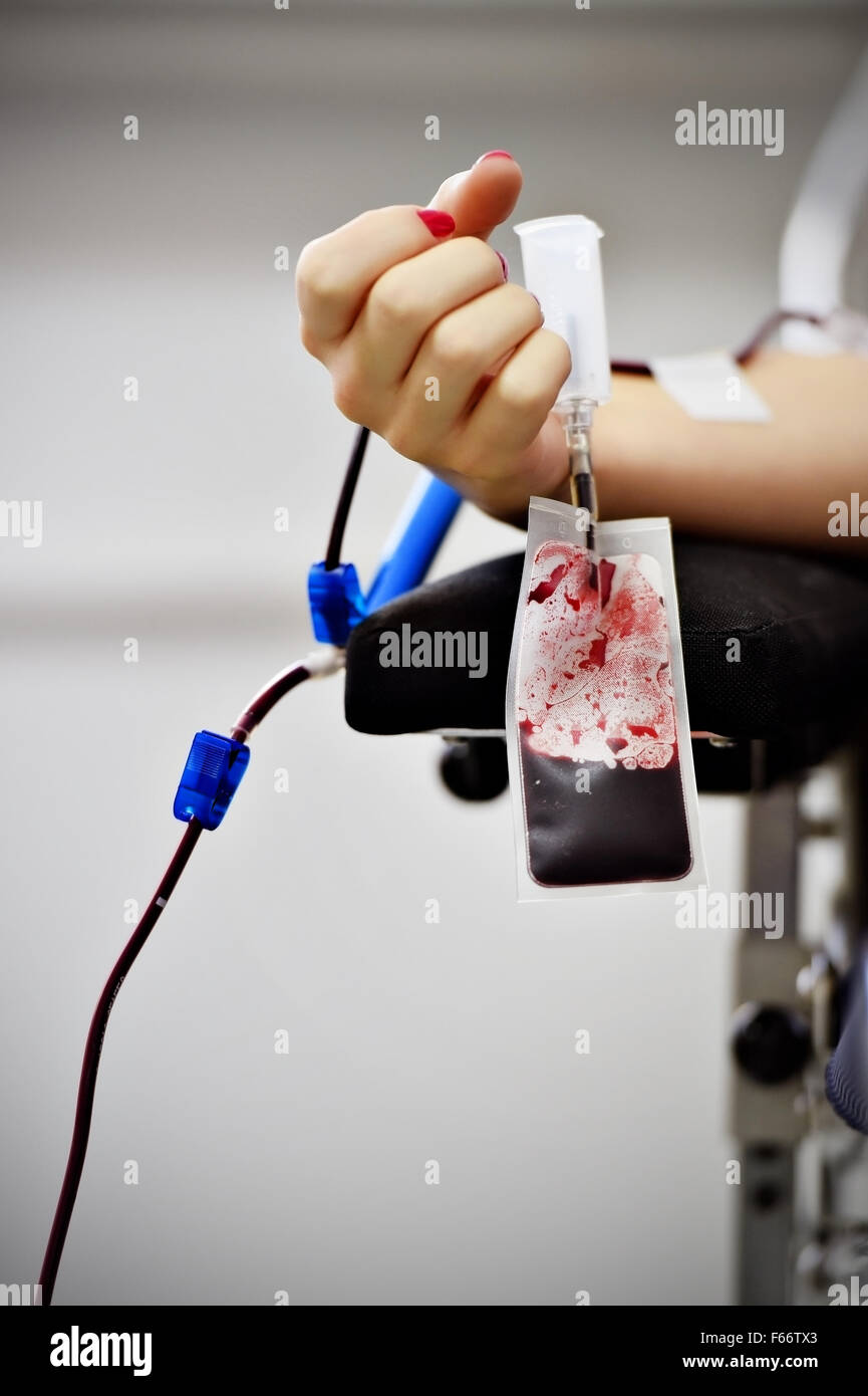 Dettaglio con la mano di un donatore di sangue e una plastica sacca di sangue in un ospedale Foto Stock