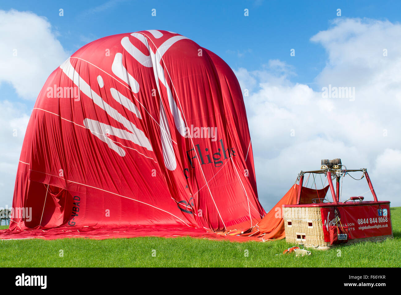 Vergine in mongolfiera ad aria calda sulla terra lentamente sgonfiare, Cumbria, Regno Unito. Foto Stock