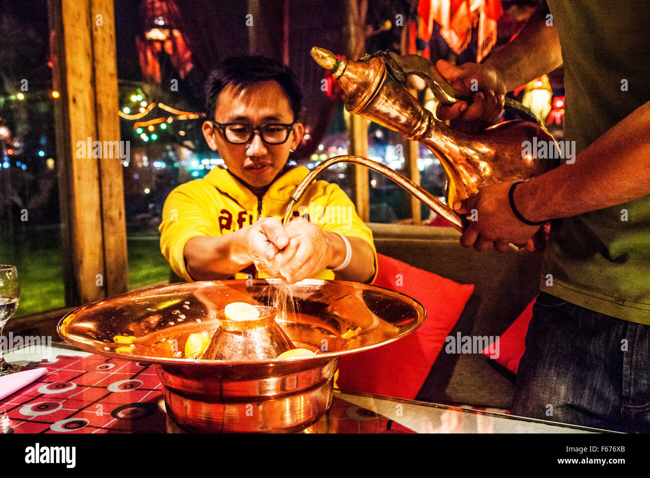 Cliente maschio si lava le mani al tavolo di un ristorante di Dahab, Egitto. Foto Stock