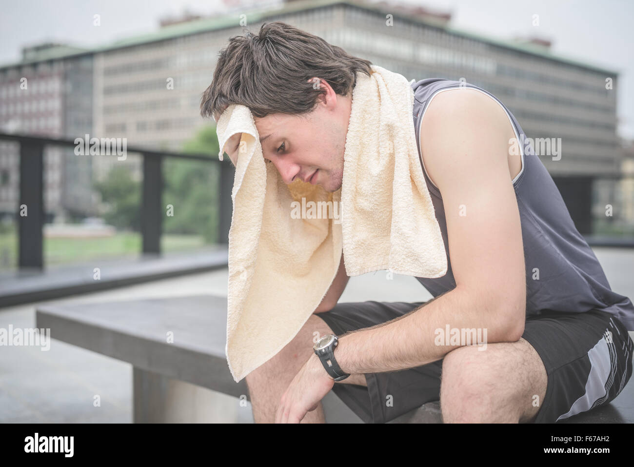 Un bell'uomo con un asciugamano intorno al collo utilizzando la schiuma da  barba mentre si scula davanti allo specchio del bagno Foto stock - Alamy