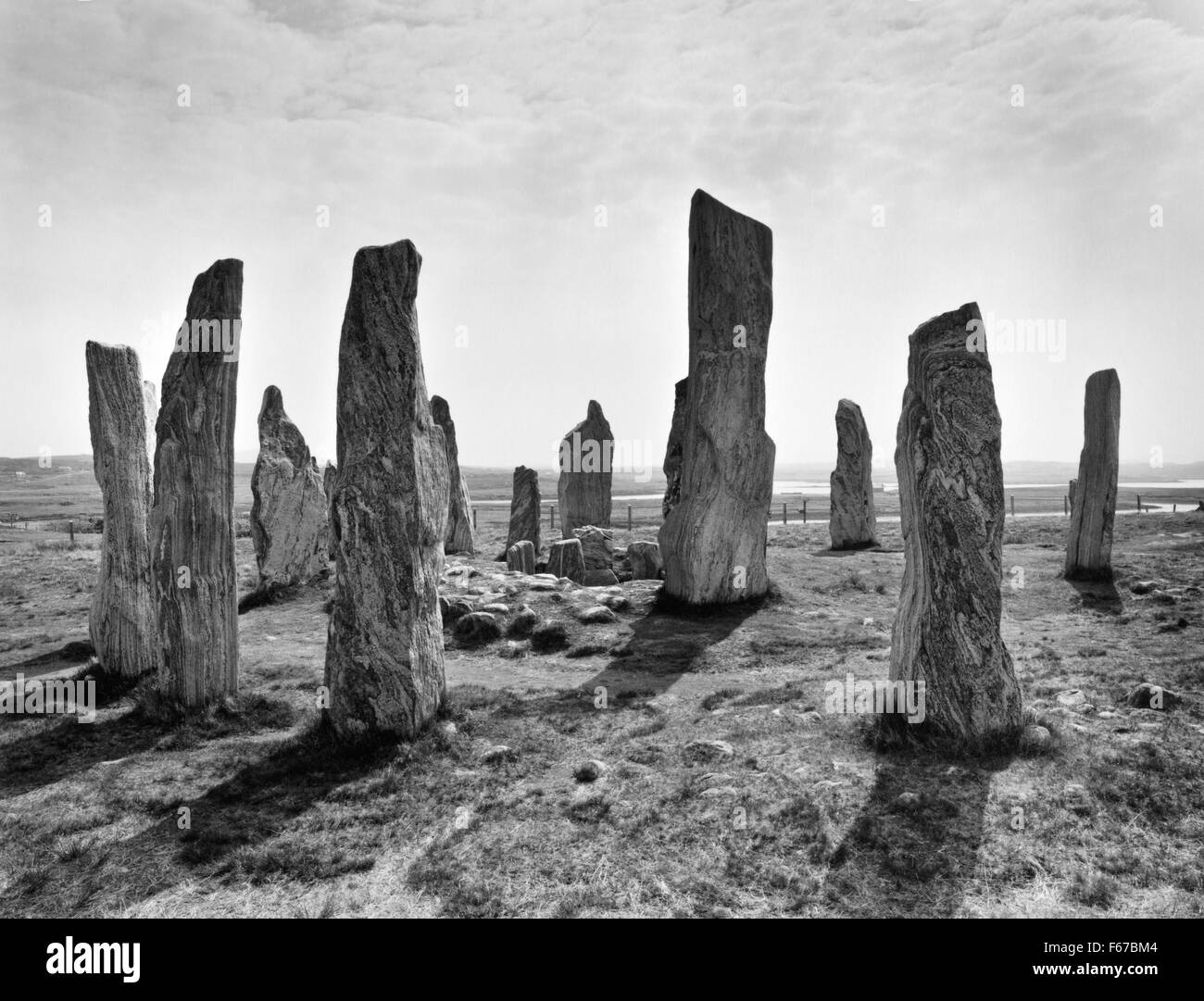 Cercando SE a Callanish (Calanais) pietre permanente, isola di Lewis, che mostra l'anello centrale con chambered cairn, alto monolito & pietre della riga e. Foto Stock