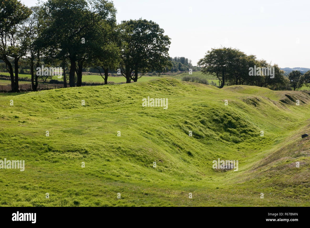 Cerca SW dalla banca esterna del Antonine Wall W di Rough Castle Roman Fort, Falkirk: profonda fossa (vallum), ampia berm, resti del terrapieno (L). Foto Stock