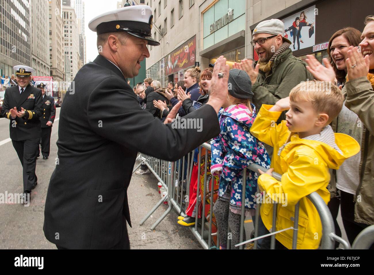 Gli Stati Uniti I marinai della marina dal trasporto anfibio dock nave USS New York salutare le persone si sono riuniti per l annuale Giornata dei veterani parade durante la settimana dei veterani Novembre 11, 2015 nella città di New York, NY. Foto Stock