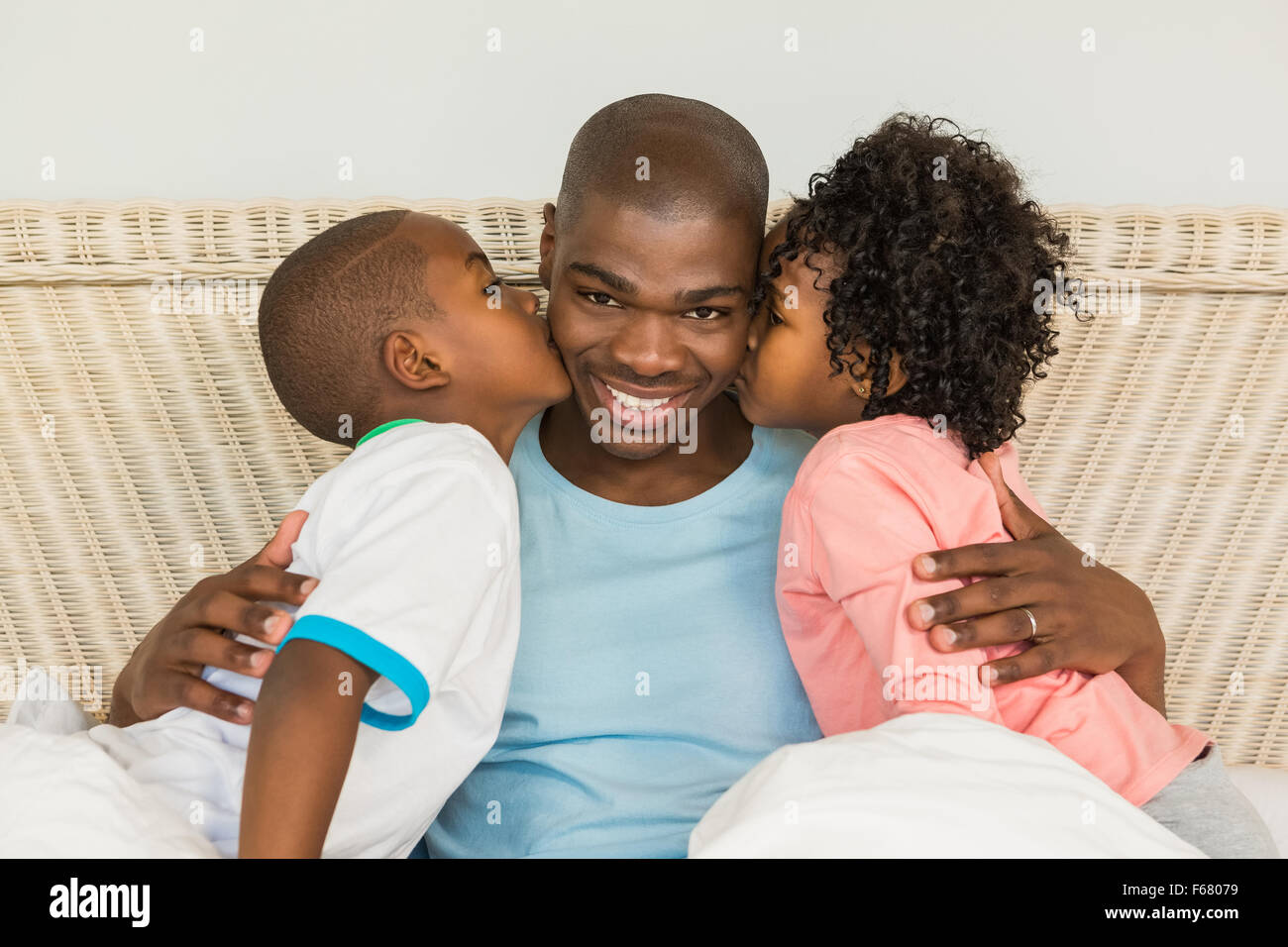 Bambini baciare padre a letto Foto Stock